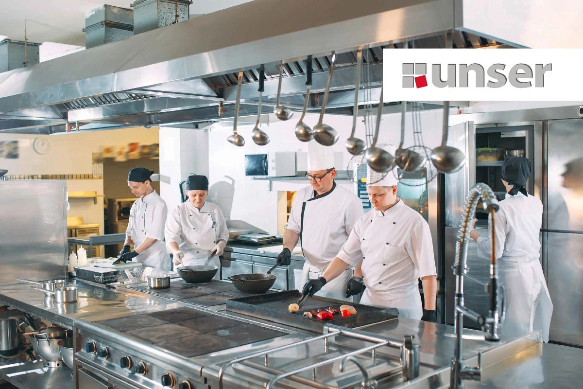 Cinco cocineros en una cocina profesional
